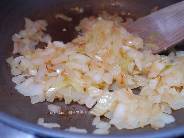 同一個鍋子，鍋內內放少許油，將洋蔥末與蒜末炒至透明且微微上色。