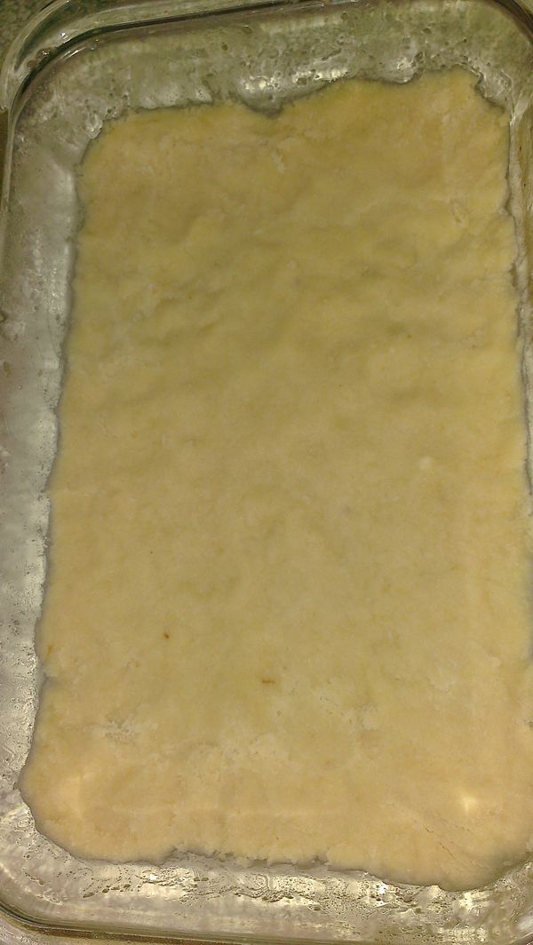 奶酥麵團轉鬆散不易成團,沒有關係的。
將烤皿底部塗上橄欖油，將一半的奶酥麵團舖於底部並按壓平。