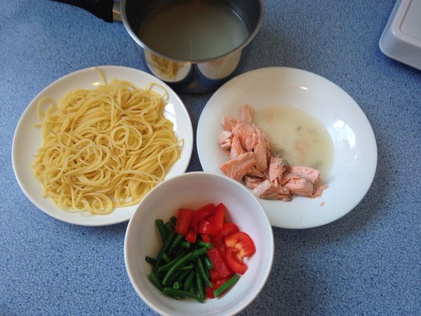 煮義大利麵。
加少許鹽及橄欖油在滾水中煮麵，煮好後撈起義大利麵，並保留煮麵水。同時可煎鮭魚，約七分熟時加入白酒及一小碗煮麵水當作高湯。鮭魚撥小塊備用。