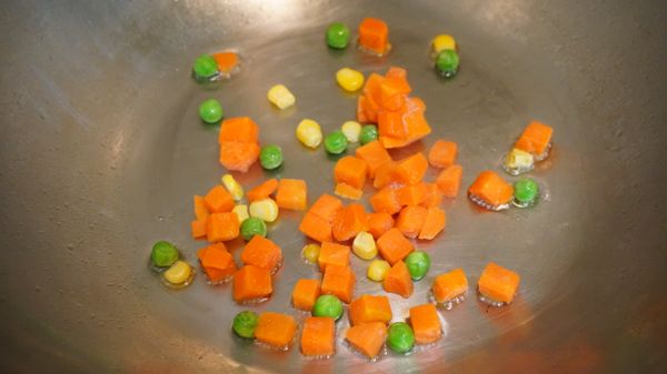 熱鍋後倒入1茶匙油，將三色豆放入鍋中拌炒。