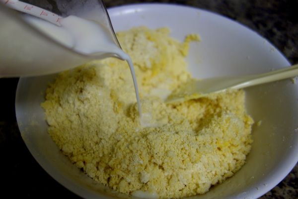 用刮刀(我喜歡用飯匙)將蛋液分次拌入奶油麵粉粒中，再慢慢少量加入冰牛奶做成麵糰。不可以揉麵出筋，不然派皮就不酥了，烤的時候還會縮!! 麵糰看起來乾乾的甚至有一些裂痕或小塊沒有黏在一起是正常的。