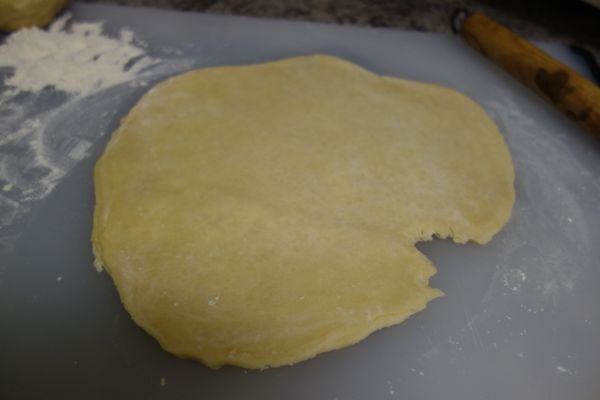 在工作檯上準備大約半杯的麵粉當手粉，擀麵棍也要均勻抹上麵粉。將麵糰稍微擀平