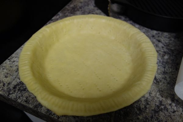 將折好的麵糰稍微整圓，再將派皮擀成直徑 約 11-12 吋圓，厚約 0.3 公分的派皮，放進派盤中。用叉子均勻在派皮邊、底上戳洞，將派盤冰回冰箱中至少 30 分鐘。(這個步驟可以冷卻剛剛擀麵產生出來的麵筋，烤的時候比較不會變形)