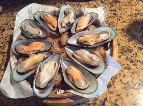 取一竹製的小蒸籠，先鋪上烘焙紙，然後倒入糯米飯，再把淡菜排在上面。