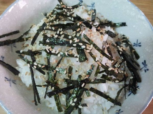 把白飯裝到碗中 , 海苔剪碎灑到白飯上 , 再灑上白芝麻