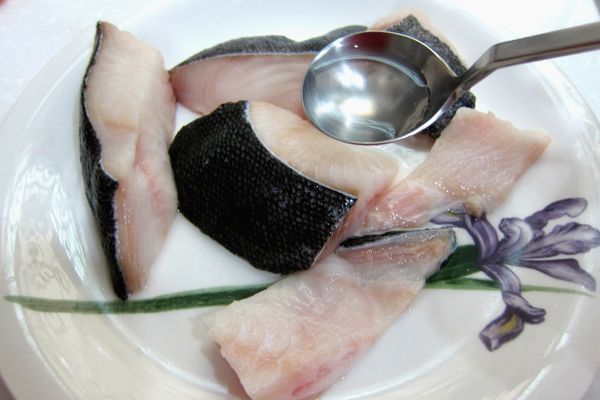 前一晚將冷凍的鱈魚塊移至冷藏解凍。取出鱈魚塊以刀刮除魚鱗後，切成四份(一併去骨處理)。以清酒(或米酒)洗去表面雜質。