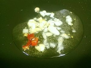 熱油鍋先爆香蒜頭及辣椒
