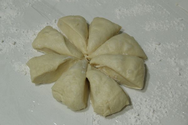 檯面上灑些麵粉，將麵糰倒出，用括刀分成 8等份