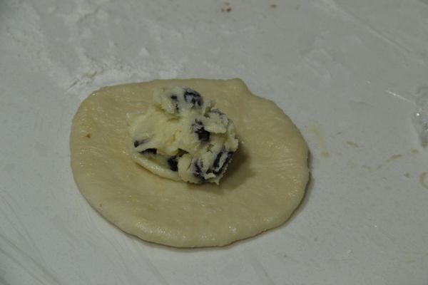 陸續將八個麵團皆橄成圓形，並放上適量 [奶酥內餡]