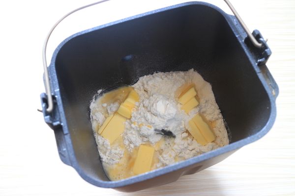 放入全蛋與水混合物，將奶油切小塊一起放入。