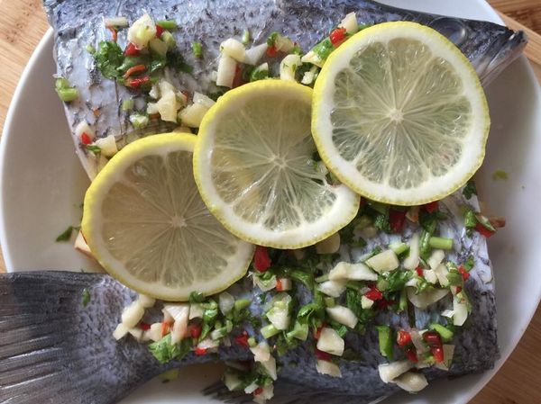 把蒸醬淋在鱸魚上，放上檸檬切片（可放可不放，或起鍋盤飾），放入電鍋，外鍋放半杯水，按下去煮，跳起就完成好吃的檸檬魚啦~