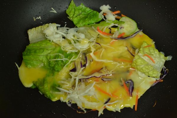 開中小火將7-11一日野菜-水果玉米鋪在平底鍋上，在打入一顆雞蛋。