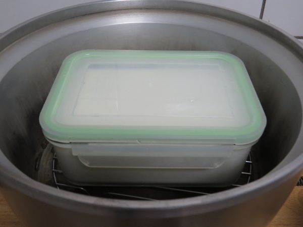 再把拌勻後的乳液，倒入己消毒過的乾淨容器內，蓋上容蓋後，放入以降溫的電鍋內