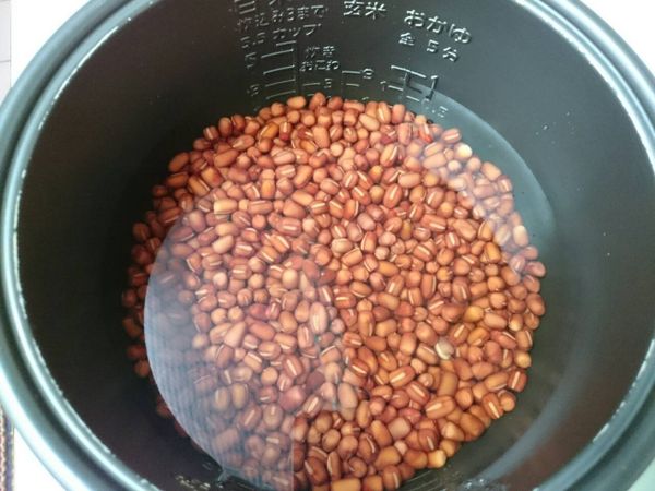 隔天，將紅豆連同浸泡的水一起倒入電子鍋內鍋中，燉煮１～１個半小時至手捏紅豆可輕易捏碎的程度。
（若用電鍋煮，則外鍋放1杯半的水蒸煮2次）