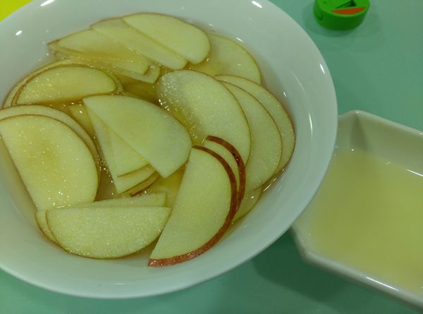 將蘋果片及擠好的檸檬汁加入碗裡，並加入水，水與蘋果同高。