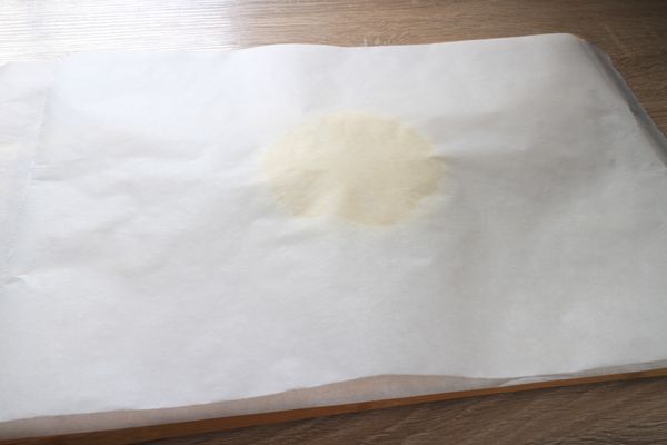 上面再鋪一層烘焙紙，以擀麵棍輕輕桿平。