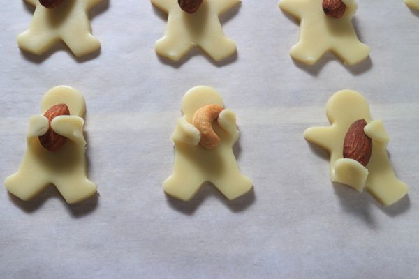 將堅果放在餅乾上，稍微輕輕壓一下，就可以開始替小人兒做造型，手可以抱著堅果、或用腳踢？記得動作要輕柔些，雖比一般餅乾麵糰有韌性，但過於用力容易造成餅乾麵糰裂開。