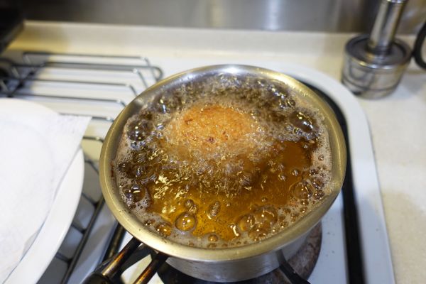 將油鍋熱到筷子放入會起小泡就是適量溫度此時可將步驟完成的蘇格蘭蛋輕輕放入油鍋炸6分鐘