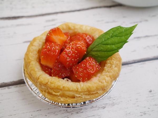 烤好的蛋塔出爐，放上草莓塊即可。