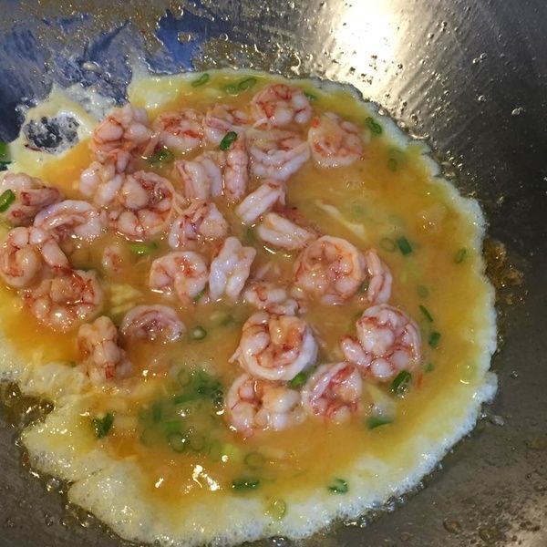 原鍋再加油後，等油熱再將蝦仁蛋液油鍋邊倒入，大火快炒二下，即關火，最後加入許魚粉調味，利用餘溫讓蛋液熟
