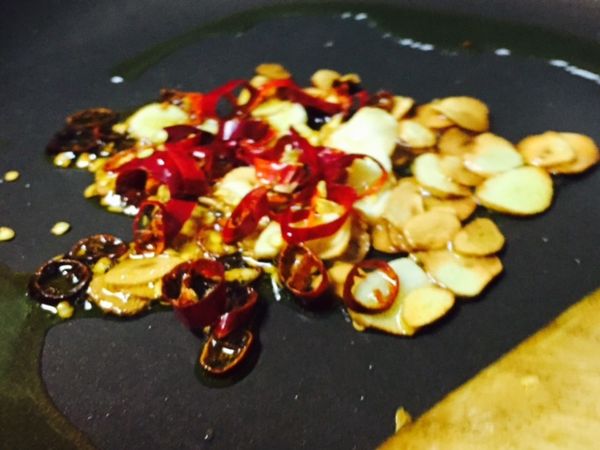 冷鍋倒入橄欖油，加入蒜片小火低溫油煎至金黃，再加入紅辣椒碎拌炒
