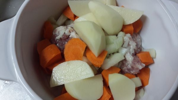 依序放入絞肉，洋蔥丁，[紅蘿蔔，馬鈴薯，切大塊些，才不會滷到最後不見]。