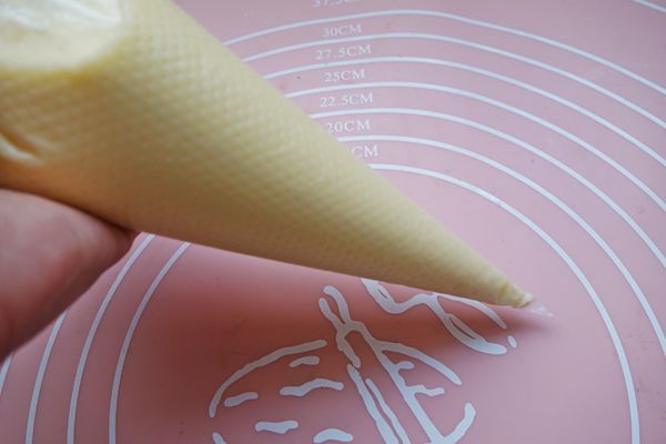 牛奶、煉奶、鮮奶油和白砂糖倒入小鍋中，開小火加熱並拌至白砂糖溶化放涼。低筋麵粉過篩，加入放涼的蛋塔液，打入蛋黃續拌均勻，拌好的蛋塔液過篩後倒人擠花袋中備用