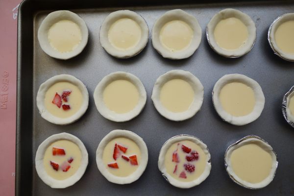 烤箱先預熱220度。塔模中擠入蛋塔液，草莓洗淨切小塊，有加草莓的做草莓蛋塔，沒有的就是原味蛋塔，入烤箱烤15分鐘。