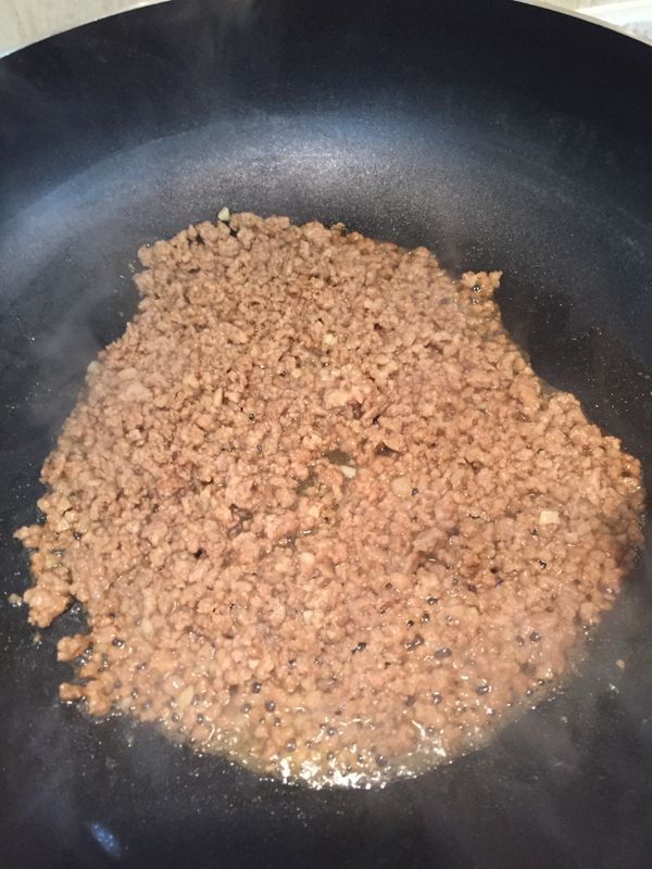 熱炒鍋，放少量油，倒入絞肉和一半的蒜末翻炒，半熟後加入米酒和醬油去腥及調味上色，熟透後呈起備用