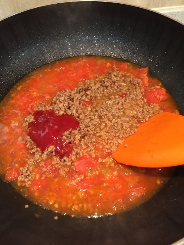 熱油鍋，倒入番茄丁翻炒，再加適量水和剩餘蒜末悶煮至半軟後，倒入肉末，番茄醬及糖，這時試試味道鹹淡再調整加入鹽巴
