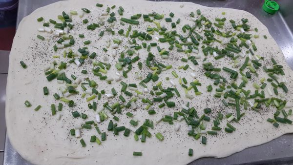 將發好的麵團,麵糰擀成長方片抹上油灑上鹽與黑胡椒,蔥花將麵皮左右都往內折