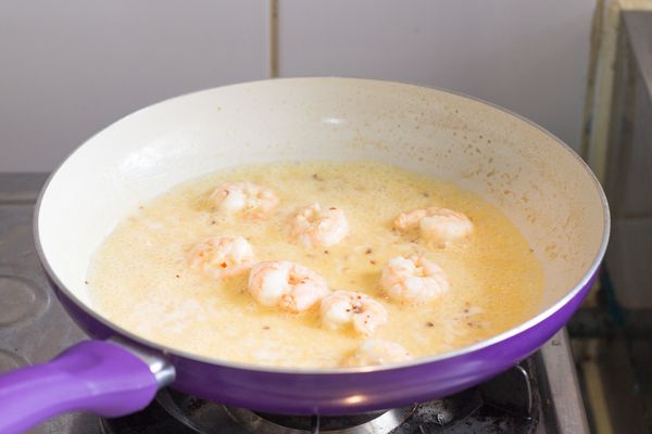 調到大火，加入白酒﹑檸檬汁﹑檸檬皮屑及直接刨入帕馬森乾酪後拌勻