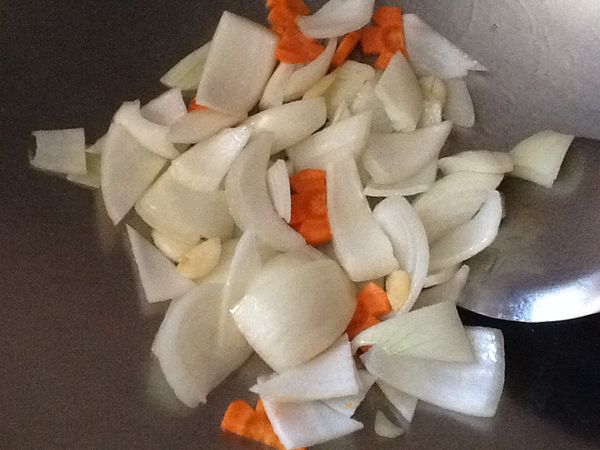 放入少許的油，先放入蒜頭爆香，再放入紅蘿蔔與洋蔥翻炒至洋蔥轉透明。