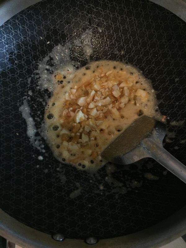 起油鍋將蒜頭爆香後放入以切碎的鹹蛋，炒至起泡泡