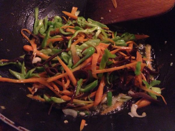 餘油放入一些蒜末，下木耳絲拌炒1分鐘，下胡蘿蔔絲再炒2分鐘，加入一些鹽，最後下青椒絲拌炒一會兒，就可以全部鏟出來備用。