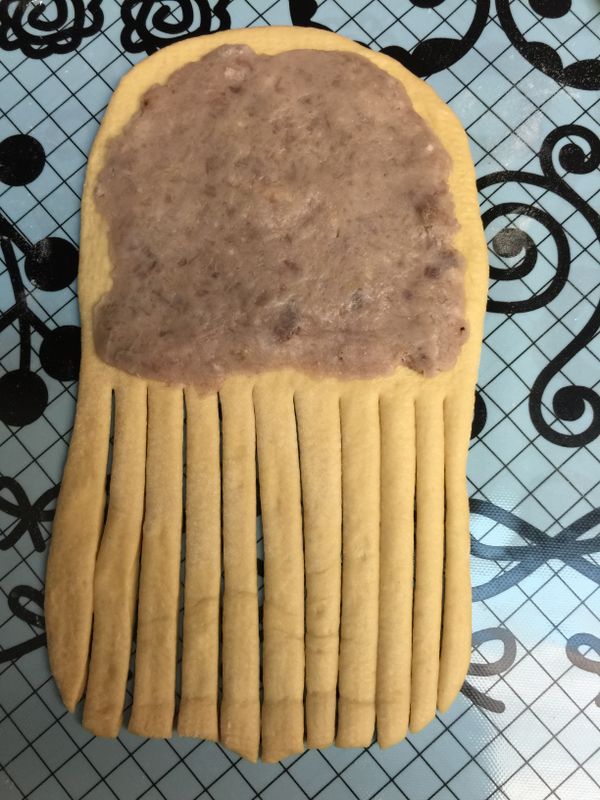 再將麵團平均分為6等份後，滾圓再鬆弛5分鐘。將麵團桿成橢圓形(約20公分長，寬8公分)，用刮板從中間的位置開始，每隔0.5公分切一長條。