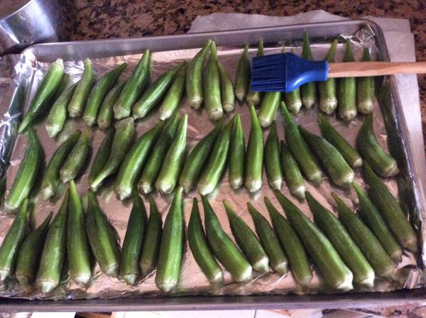用刷子沾上油，刷在秋葵的兩面。排在鋪上錫紙的烤盤上。鋪紙是為清理方便。