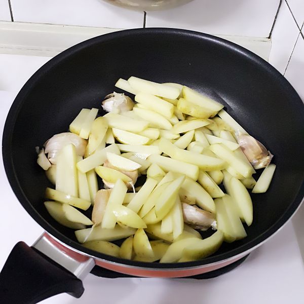 接著將切條的馬鈴薯及蒜頭放入