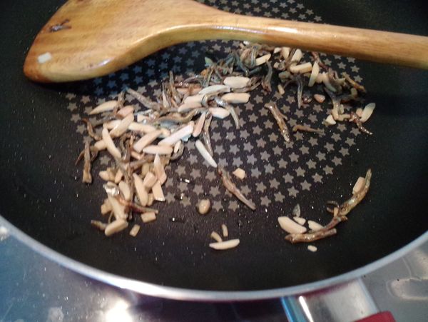 鍋中倒入橄欖油，薑末、杏仁小魚乾加入拌炒