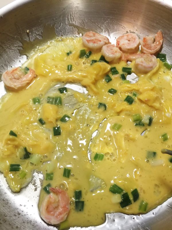 接著下蛋汁，放蝦仁，用筷子快速翻炒一下蛋，就可以起鍋