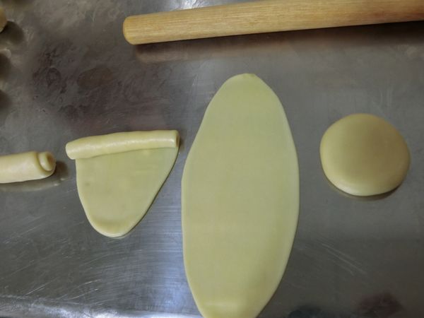 【油皮】包【油酥】成油酥皮，將油酥皮擀成牛舌餅狀，由上至下把油皮捲起，放直，再重複一次，然後壓平擀薄成餅皮