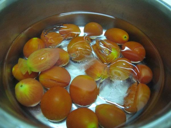 撈起小蕃茄至冰水,冰鎮後將小蕃茄皮衣褪去
