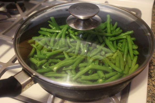 四季豆去頭尾，洗淨切段，蔥薑切細末，蝦米泡水備用；
鍋中放油，先炒四季豆，我用中火炒了約10分鐘，期間需要時常拌炒；