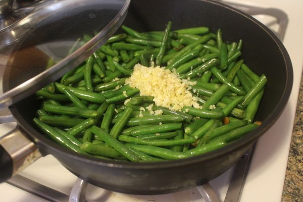 四季豆快炒好時，加入蝦米，絞肉，薑蒜末拌炒；