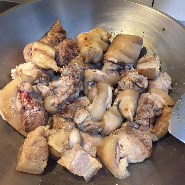 熱鍋後乾鍋把豬腳放下去煎，煎到香氣出來，接下來加入二砂炒出糖色，再嗆入米酒炒，最後再加入醬油炒香