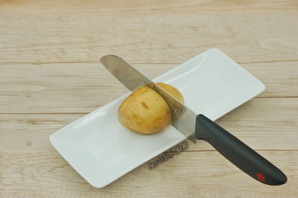 準備一個盤子,將馬鈴薯切成手風琴狀(間隔約0.2cm)不要切到底,保留底部5/1不切斷。可利用盤子的高度來切馬鈴薯,只要刀子切下時碰到盤子邊緣就可以了。