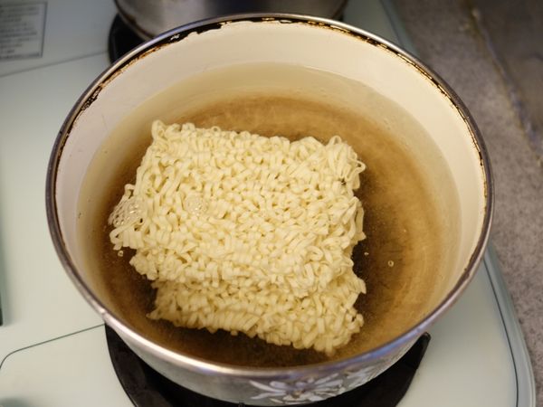 另一起鍋滾水烹煮五木肉燥味拉麵至七分軟硬，可加入調味料一包。