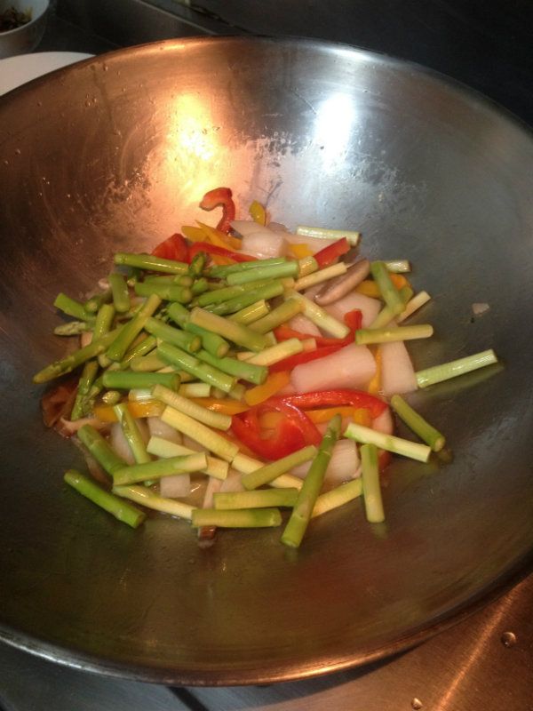 接著放入蘆筍，快速拌煮起鍋，最後灑上少許香菜