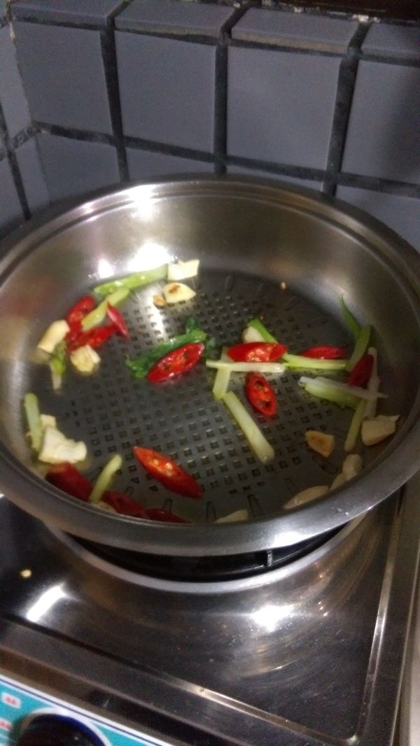 熱鍋加1-2大匙酒，爆先薑片，再爆蒜，再加蔥跟辣椒炒香。