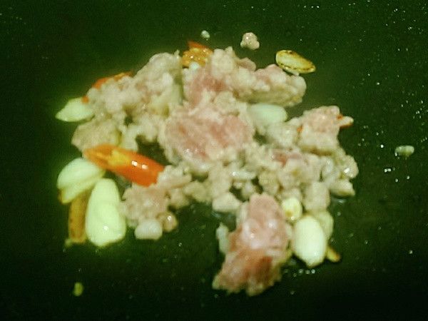 炒鍋先加入一大匙沙拉油再加入豬絞肉蒜頭與辣椒先爆香。